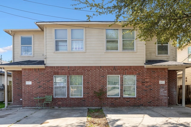 rear view of house with a patio area and brick siding