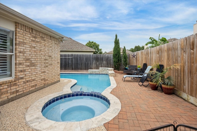 view of pool featuring a patio area, a fenced backyard, and a pool with connected hot tub