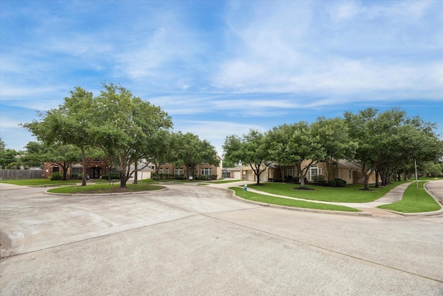 view of concrete street with curbs, sidewalks, and a residential view