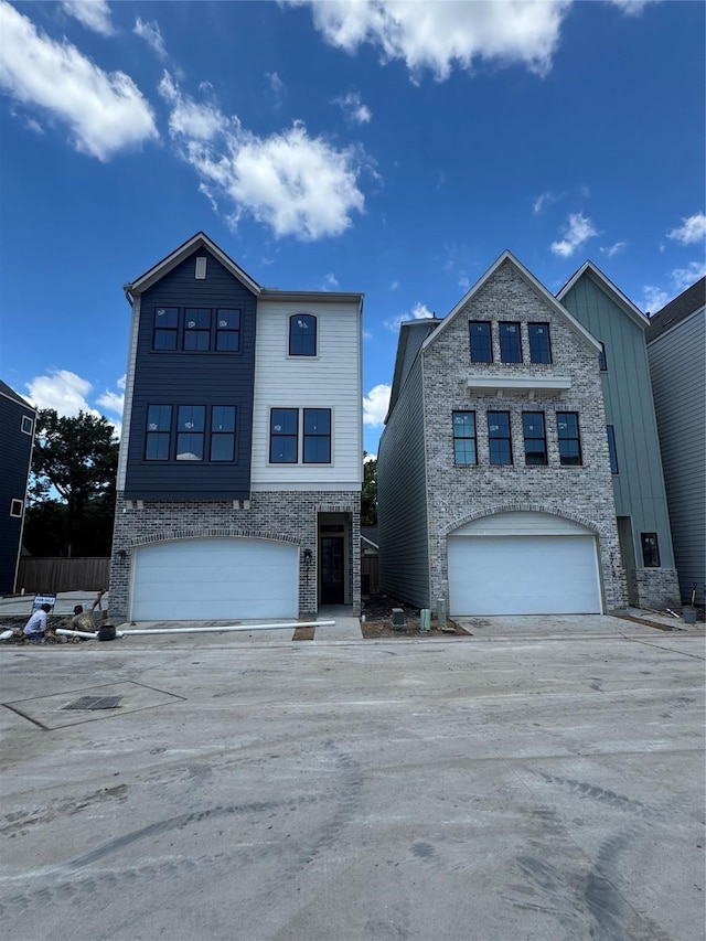 1711 Bologna Ln, Houston, TX 77055 - view of front of property featuring a garage, board and batten siding, stone siding, and brick siding