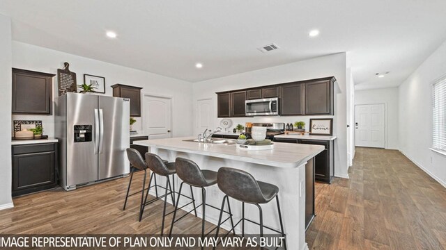 5427 Magnolia Heath Ln, Spring, TX 77373 - kitchen featuring stainless steel appliances, light countertops, dark brown cabinets, wood finished floors, and recessed lighting