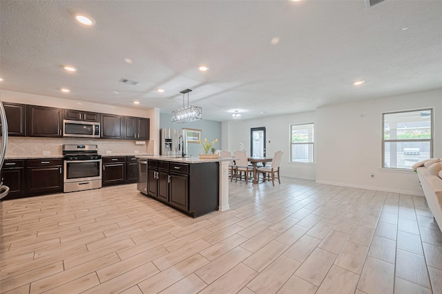 20864 Sheffield Park Dr, Porter, TX 77365 - kitchen with appliances with stainless steel finishes, open floor plan, recessed lighting, baseboards, and light wood finished floors