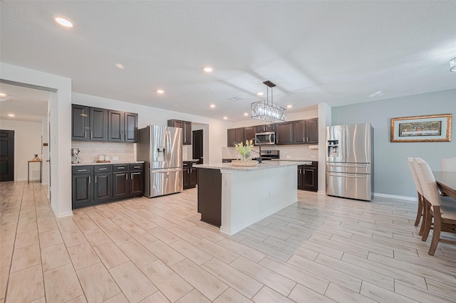 20864 Sheffield Park Dr, Porter, TX 77365 - kitchen featuring appliances with stainless steel finishes, recessed lighting, dark brown cabinetry, hanging light fixtures, and baseboards