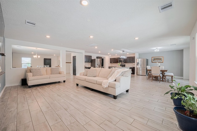 20864 Sheffield Park Dr, Porter, TX 77365 - living area with baseboards, a textured ceiling, recessed lighting, and light wood-style floors