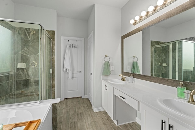 107 San Jacinto Dr, Baytown, TX 77523 - bathroom featuring a shower stall, double vanity, wood finished floors, and a bath