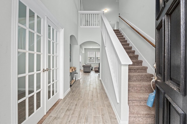107 San Jacinto Dr, Baytown, TX 77523 - entryway with arched walkways, light wood finished floors, stairway, a high ceiling, and baseboards