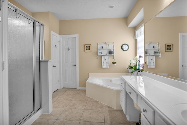 full bathroom featuring a stall shower, tile patterned flooring, a jetted tub, and double vanity
