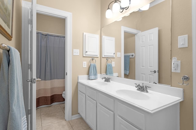 bathroom with tile patterned flooring, double vanity, and toilet