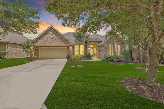 view of front of house featuring a garage, concrete driveway, and a front lawn