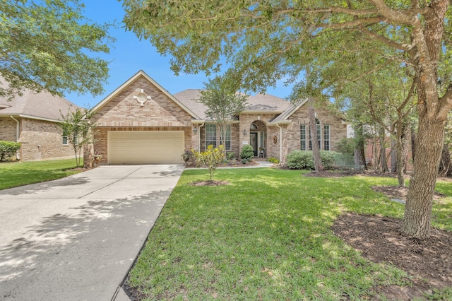 view of front of property featuring a garage, a front yard, driveway, brick siding, and a shingled roof