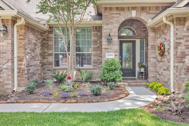 view of exterior entry with brick siding