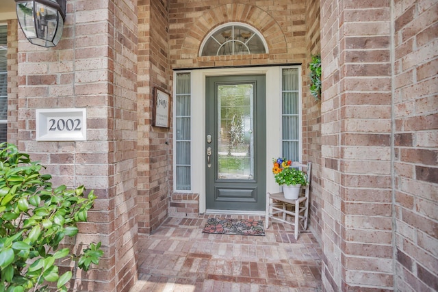 entrance to property featuring brick siding