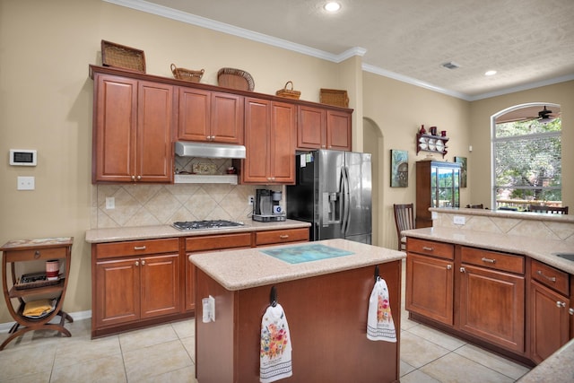 kitchen featuring stainless steel appliances, arched walkways, light tile patterned floors, a kitchen island, and recessed lighting