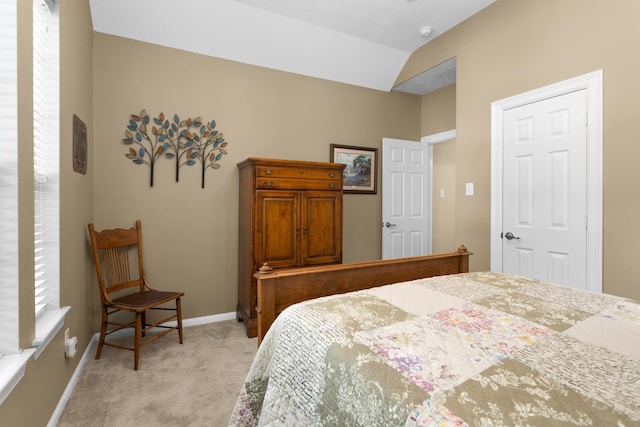bedroom featuring light colored carpet, baseboards, and vaulted ceiling