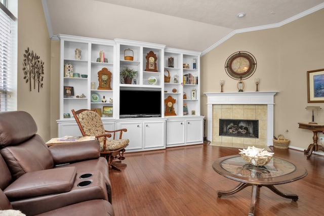 living room featuring lofted ceiling, wood finished floors, a tile fireplace, and ornamental molding