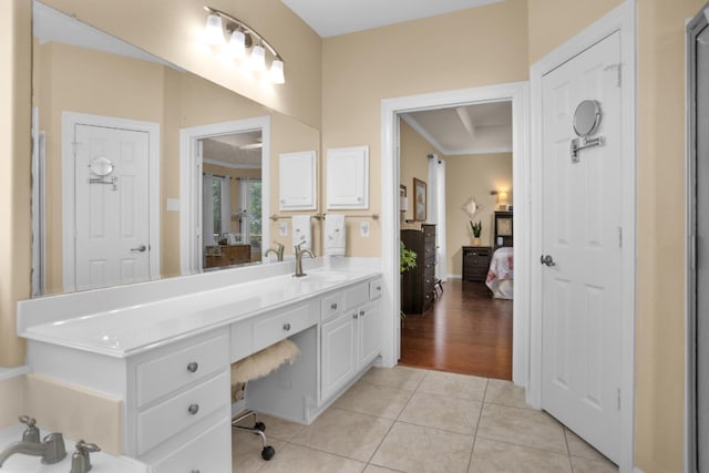 ensuite bathroom with tile patterned floors, vanity, and crown molding