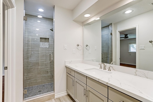 full bath featuring recessed lighting, a shower stall, vanity, a ceiling fan, and baseboards