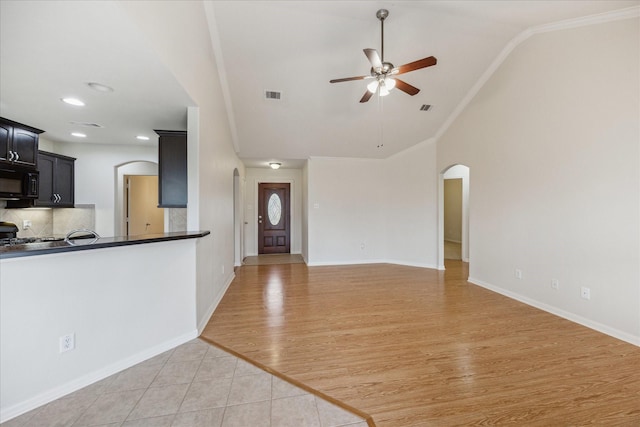 243 S Lantana Cir, Sealy, TX 77474 - unfurnished living room featuring arched walkways, ceiling fan, vaulted ceiling, crown molding, and recessed lighting