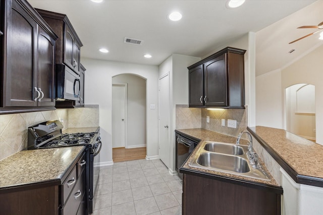 243 S Lantana Cir, Sealy, TX 77474 - kitchen with arched walkways, black appliances, a sink, dark brown cabinets, and recessed lighting