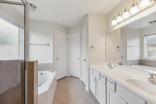 243 S Lantana Cir, Sealy, TX 77474 - full bathroom featuring a garden tub, double vanity, and tile patterned floors