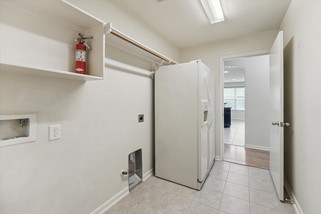 243 S Lantana Cir, Sealy, TX 77474 - laundry room with hookup for an electric dryer, light tile patterned floors, washer hookup, and baseboards