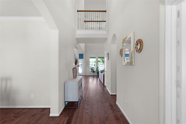 9615 Carson Ln, Iowa Colony, TX 77583 - hall with arched walkways, dark wood-style flooring, baseboards, ornamental molding, and a high ceiling