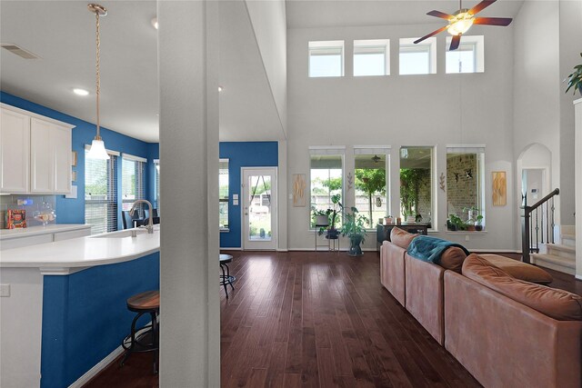 9615 Carson Ln, Iowa Colony, TX 77583 - living room featuring ceiling fan, a high ceiling, dark wood-style floors, stairway, and recessed lighting
