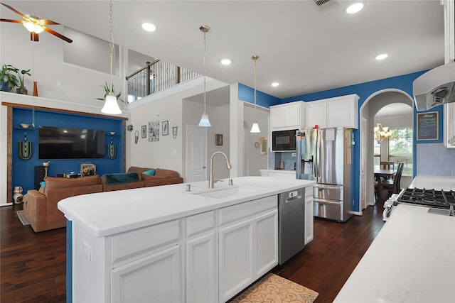 9615 Carson Ln, Iowa Colony, TX 77583 - kitchen featuring a sink, stainless steel appliances, open floor plan, arched walkways, and dark wood finished floors