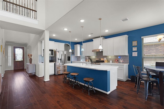 9615 Carson Ln, Iowa Colony, TX 77583 - kitchen featuring appliances with stainless steel finishes, light countertops, dark wood-style flooring, tasteful backsplash, and recessed lighting