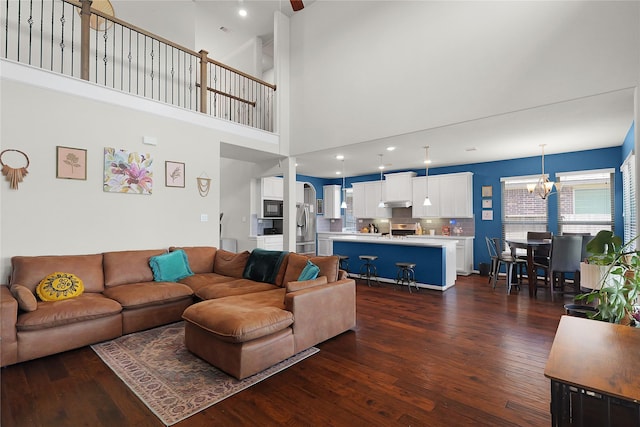 9615 Carson Ln, Iowa Colony, TX 77583 - living room featuring dark wood-style floors, a chandelier, and a high ceiling
