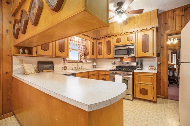 kitchen featuring appliances with stainless steel finishes, light flooring, light countertops, and a peninsula