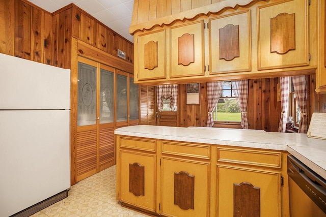 kitchen featuring freestanding refrigerator, stainless steel dishwasher, light floors, and light countertops
