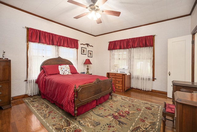 bedroom with crown molding, wood finished floors, baseboards, and a ceiling fan