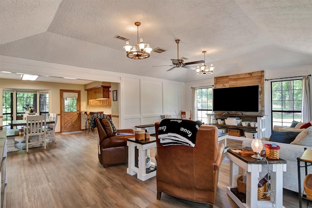26410 Anderson Rd, Magnolia, TX 77354 - living room with a chandelier, lofted ceiling, wood finished floors, a textured ceiling, and plenty of natural light