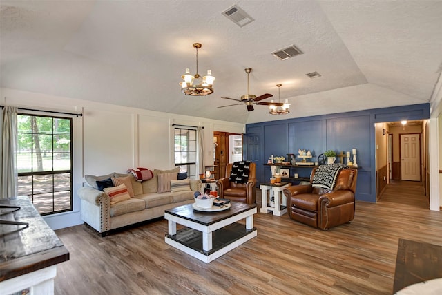 26410 Anderson Rd, Magnolia, TX 77354 - living room featuring a decorative wall, lofted ceiling, a chandelier, wood finished floors, and ceiling fan