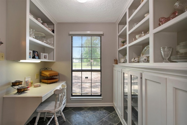 26410 Anderson Rd, Magnolia, TX 77354 - office space featuring a textured ceiling, baseboards, and dark tile patterned floors