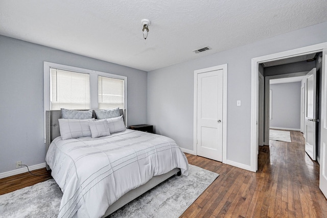 1215 Ashland St, Houston, TX 77008 - bedroom with dark wood-type flooring, baseboards, and a textured ceiling