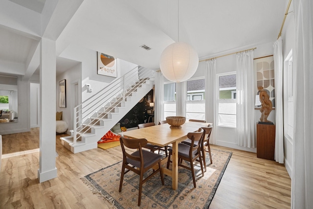 717 E 23rd St, Houston, TX 77008 - dining space with stairway, light wood-style floors, and baseboards