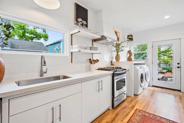717 E 23rd St, Houston, TX 77008 - kitchen featuring gas range, a sink, open shelves, separate washer and dryer, and backsplash