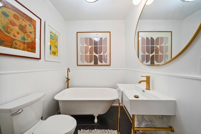 717 E 23rd St, Houston, TX 77008 - bathroom with toilet, a sink, a freestanding tub, and a wainscoted wall