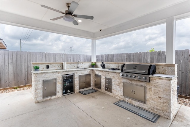 22022 Guston Hall Ln, Katy, TX 77449 - view of patio / terrace featuring grilling area, an outdoor kitchen, a fenced backyard, and wine cooler