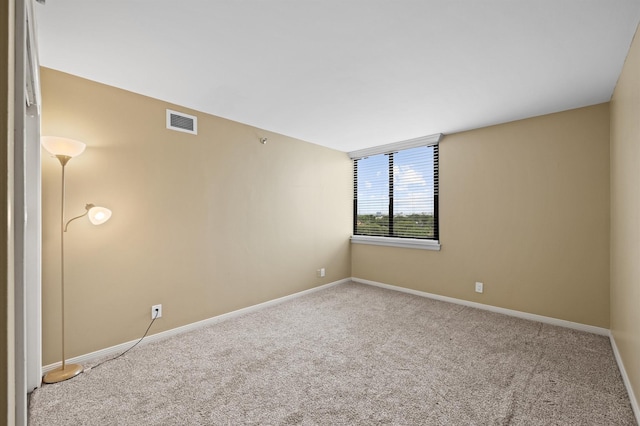 carpeted spare room featuring baseboards