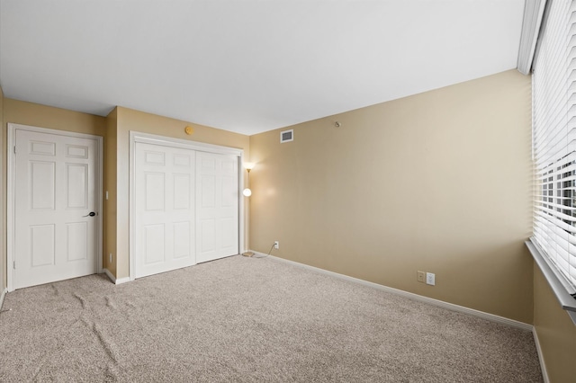 unfurnished bedroom with carpet flooring, a closet, and baseboards