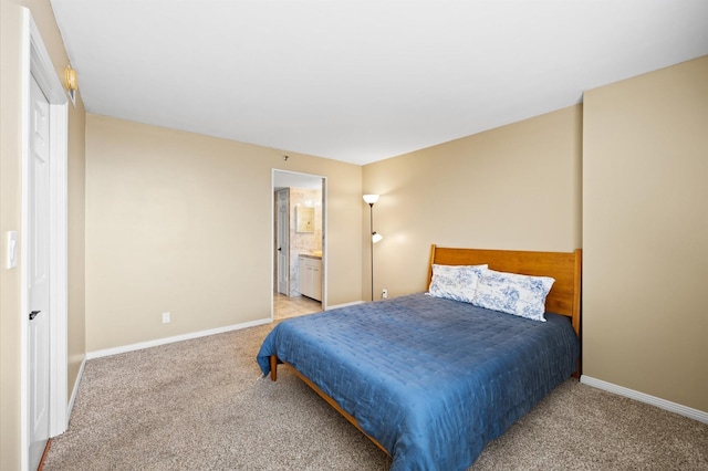 bedroom featuring light carpet, baseboards, and ensuite bathroom