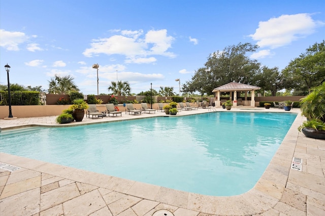 community pool featuring a gazebo, a patio area, and fence