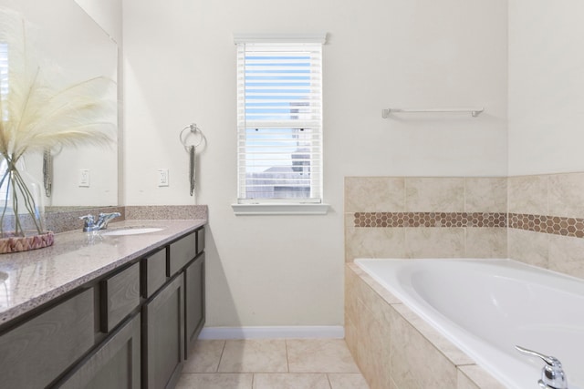 full bathroom with tile patterned floors, a bath, vanity, and baseboards