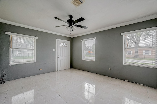 empty room with ornamental molding, a ceiling fan, and light tile patterned flooring