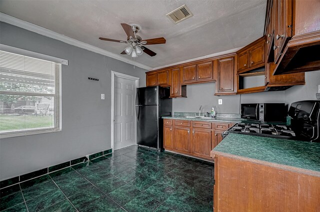 kitchen featuring black appliances, ceiling fan, crown molding, brown cabinets, and a sink