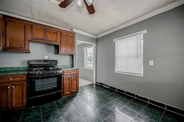 kitchen featuring black range with gas stovetop, ornamental molding, ceiling fan, baseboards, and brown cabinets