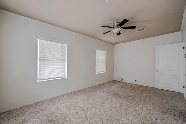 spare room featuring carpet flooring, ornamental molding, and a ceiling fan